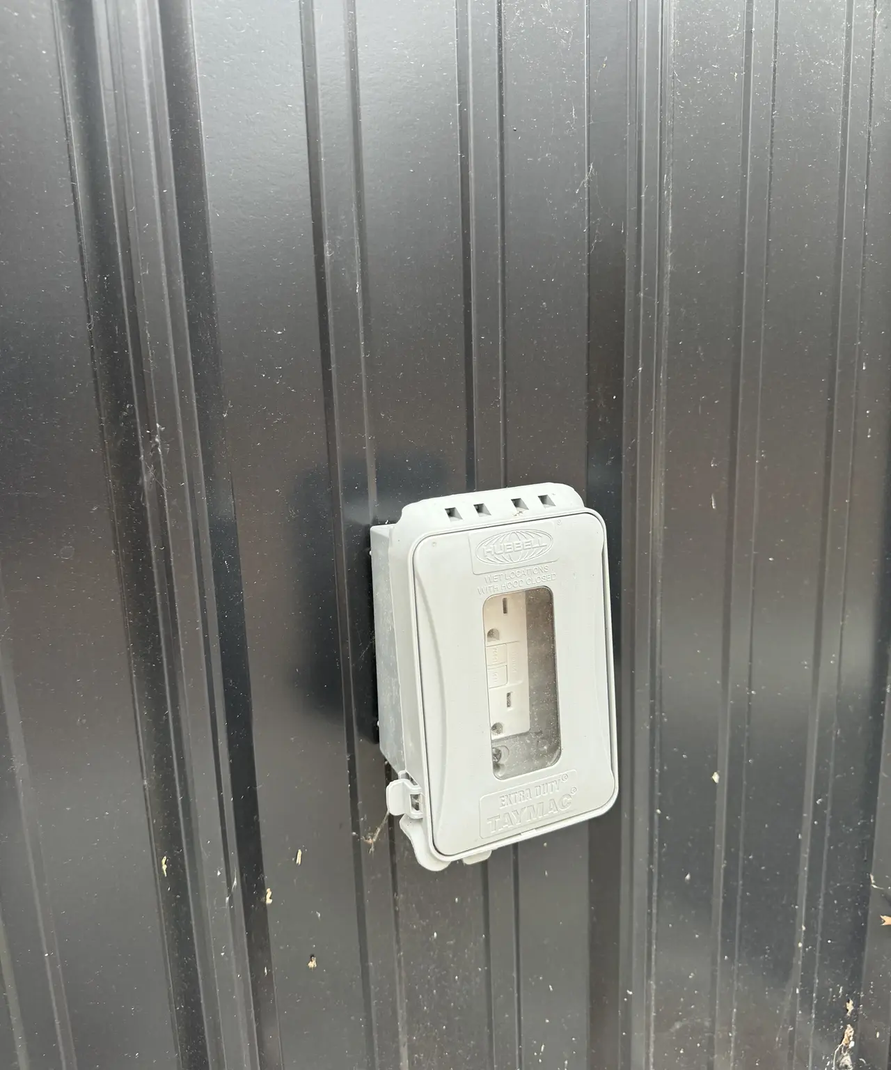 Weather-protected outdoor outlet installed on exterior siding